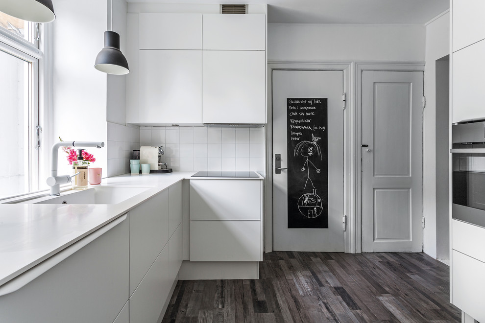 Photo of a mid-sized scandinavian l-shaped separate kitchen in Copenhagen with flat-panel cabinets and white cabinets.