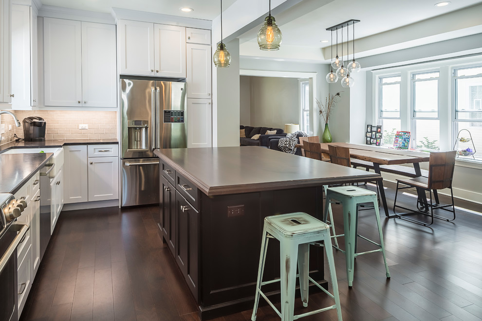 Large transitional galley dark wood floor open concept kitchen photo in Chicago with a farmhouse sink, recessed-panel cabinets, quartzite countertops, gray backsplash, ceramic backsplash, stainless steel appliances and an island