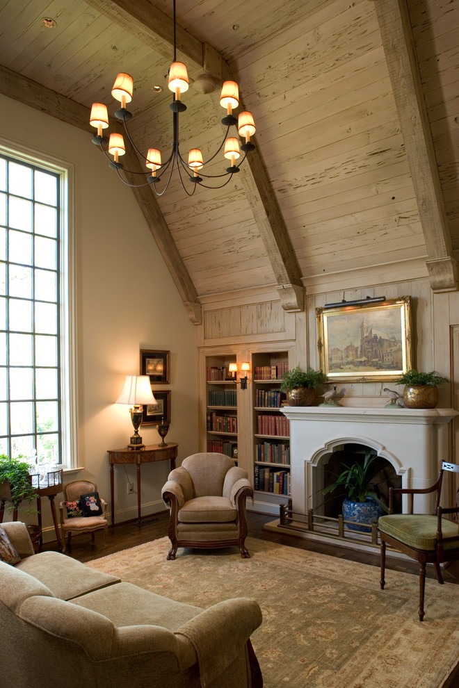 Inspiration for a large traditional study room in Birmingham with beige walls, dark hardwood floors, a standard fireplace, a plaster fireplace surround and brown floor.