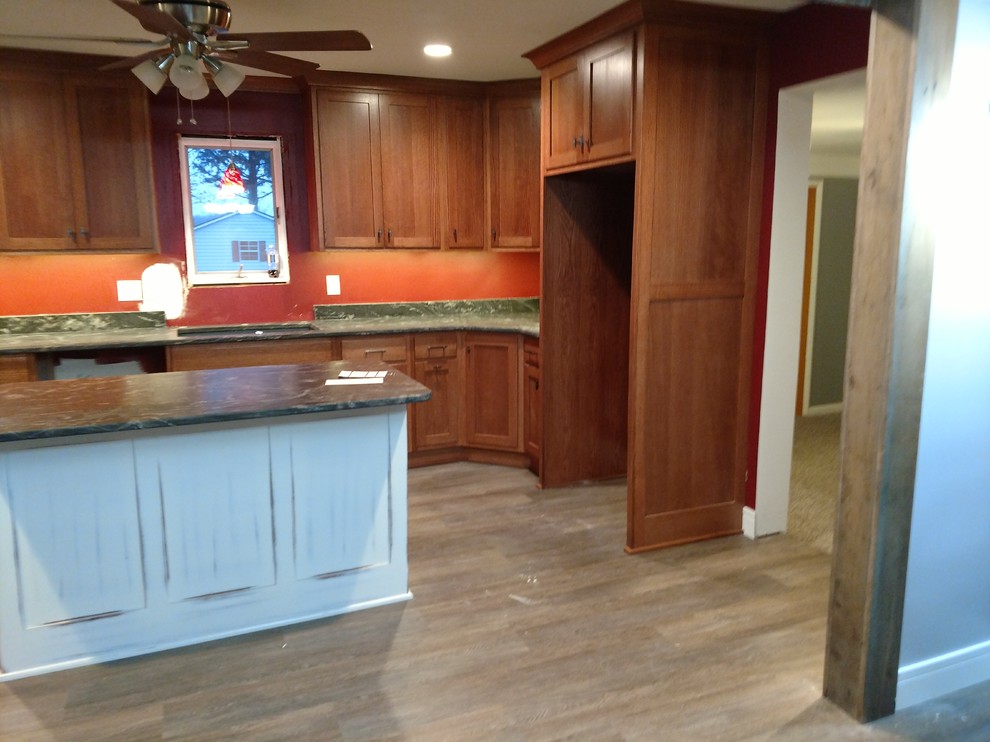 Large transitional u-shaped kitchen photo with recessed-panel cabinets, medium tone wood cabinets, granite countertops, multicolored backsplash, an island and multicolored countertops