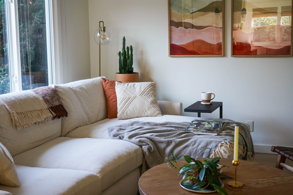 Immagine di un grande soggiorno stile marinaro aperto con pareti bianche e parquet chiaro