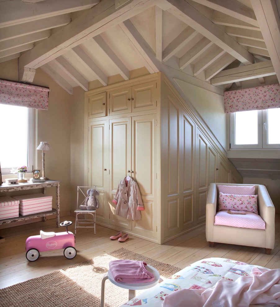 This is an example of a mid-sized traditional kids' playroom for kids 4-10 years old and girls in Madrid with beige walls and light hardwood floors.