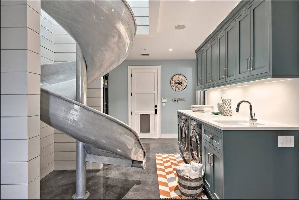 Design ideas for a contemporary laundry room in Austin with recessed-panel cabinets, turquoise cabinets, concrete floors, a side-by-side washer and dryer and grey floor.