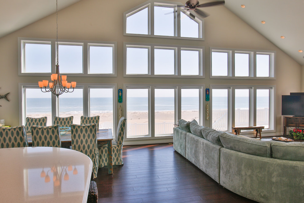 This is an example of a mid-sized beach style open plan dining in Other with white walls, dark hardwood floors, no fireplace and brown floor.