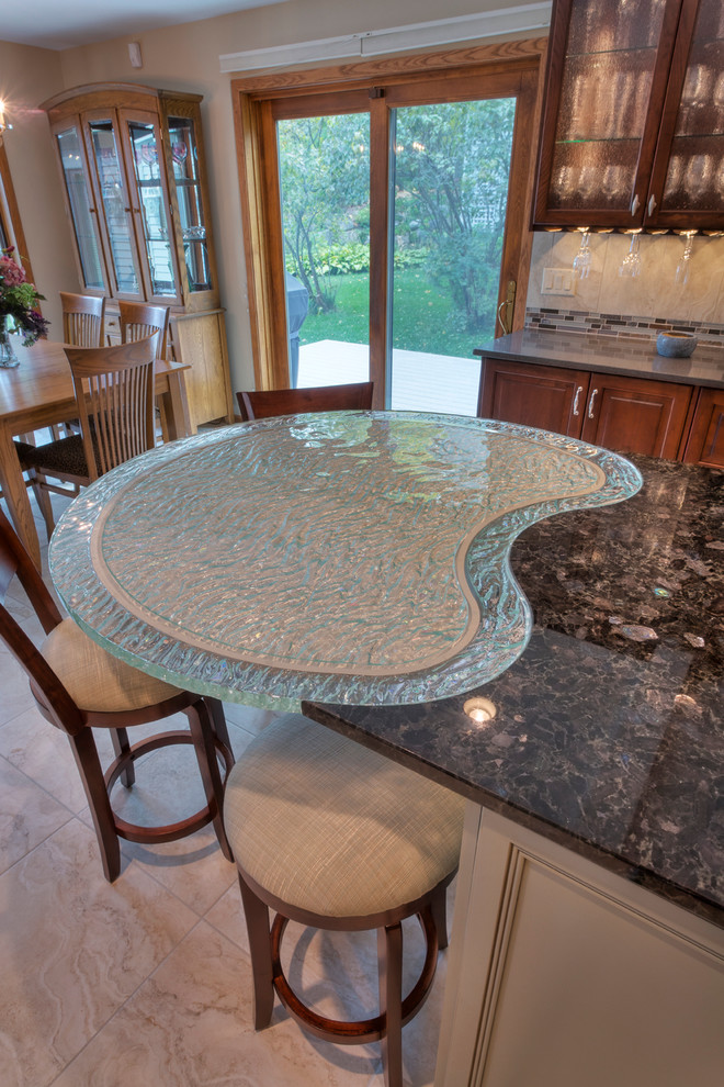 Large transitional l-shaped ceramic tile eat-in kitchen photo with an undermount sink, raised-panel cabinets, medium tone wood cabinets, glass countertops, multicolored backsplash, mosaic tile backsplash, paneled appliances and an island