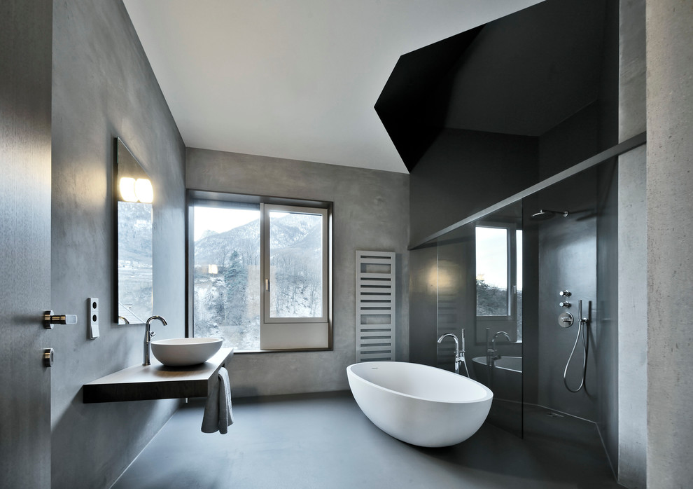 Inspiration for a large modern master bathroom in Other with a vessel sink, a freestanding tub, a corner shower, grey walls, concrete floors, wood benchtops and brown benchtops.
