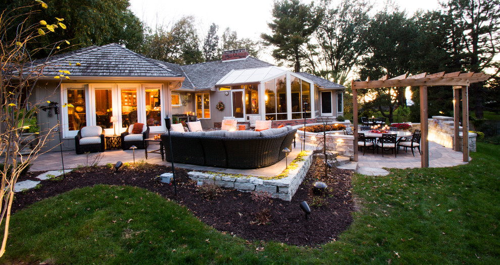 This is an example of a transitional backyard stone water fountain landscape in Omaha.