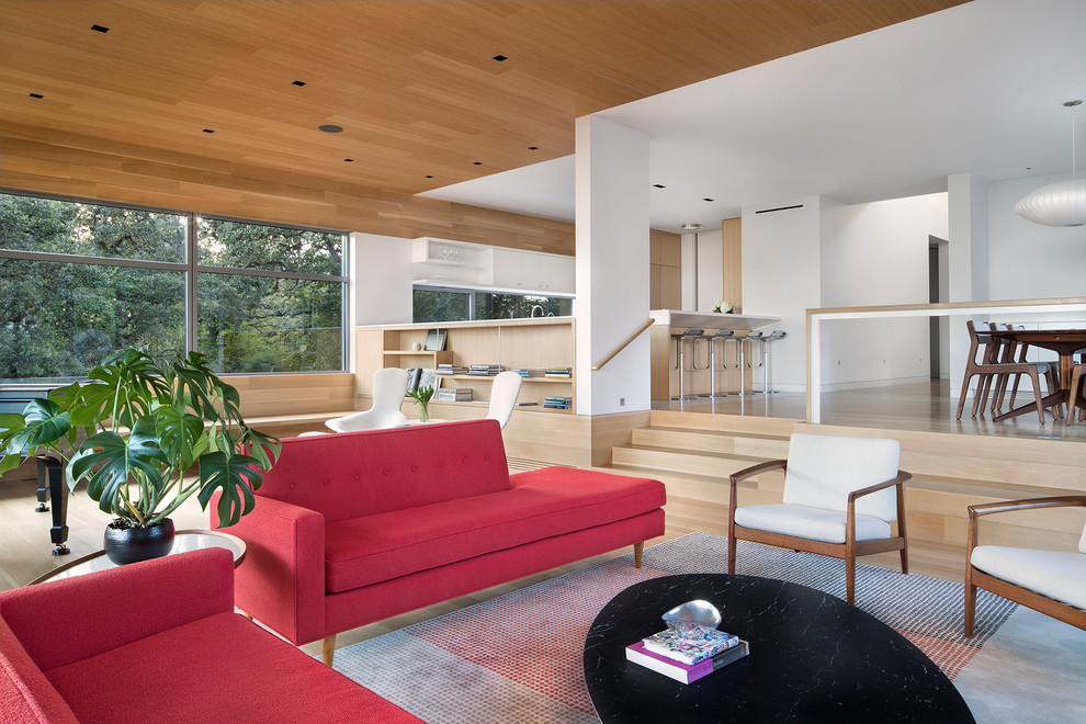 This is an example of a large midcentury formal open concept living room in Austin with white walls, light hardwood floors, no fireplace and no tv.