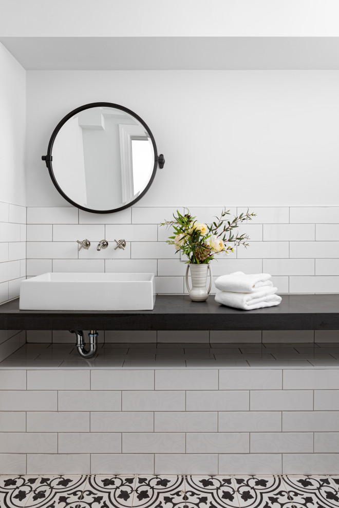 Diseño de cuarto de baño único y flotante actual pequeño con baldosas y/o azulejos blancos, baldosas y/o azulejos de cemento, paredes blancas, suelo de azulejos de cemento, aseo y ducha, lavabo sobreencimera, encimera de ónix, suelo multicolor y encimeras negras