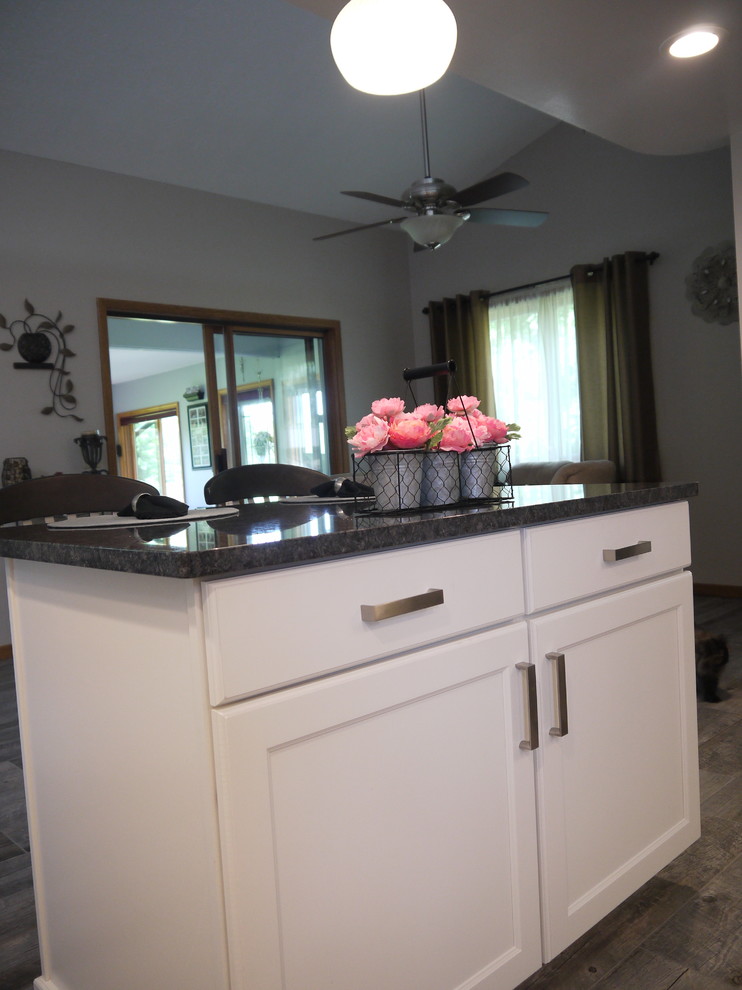 Small transitional u-shaped kitchen in Grand Rapids with a double-bowl sink, recessed-panel cabinets, white cabinets, granite benchtops, multi-coloured splashback, glass tile splashback, stainless steel appliances and with island.