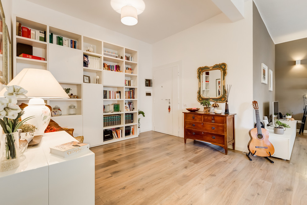 This is an example of a large contemporary foyer in Rome with white walls, light hardwood floors, a single front door and a white front door.