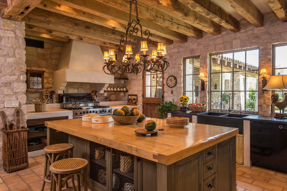 Inspiration for a large country galley eat-in kitchen in Phoenix with a double-bowl sink, recessed-panel cabinets, beige cabinets, wood benchtops, beige splashback, stone tile splashback, stainless steel appliances, terra-cotta floors and with island.