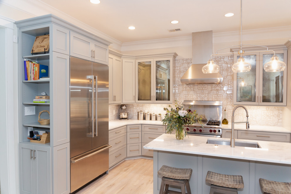Mid-sized transitional l-shaped light wood floor and beige floor open concept kitchen photo in Charleston with an undermount sink, recessed-panel cabinets, gray cabinets, quartzite countertops, gray backsplash, marble backsplash, stainless steel appliances, an island and gray countertops