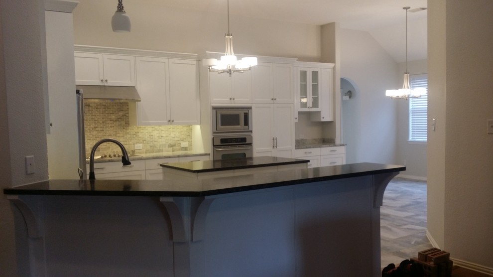 This is an example of a large traditional u-shaped eat-in kitchen in Dallas with a double-bowl sink, recessed-panel cabinets, white cabinets, granite benchtops, brown splashback, stone tile splashback, stainless steel appliances, ceramic floors, with island and grey floor.