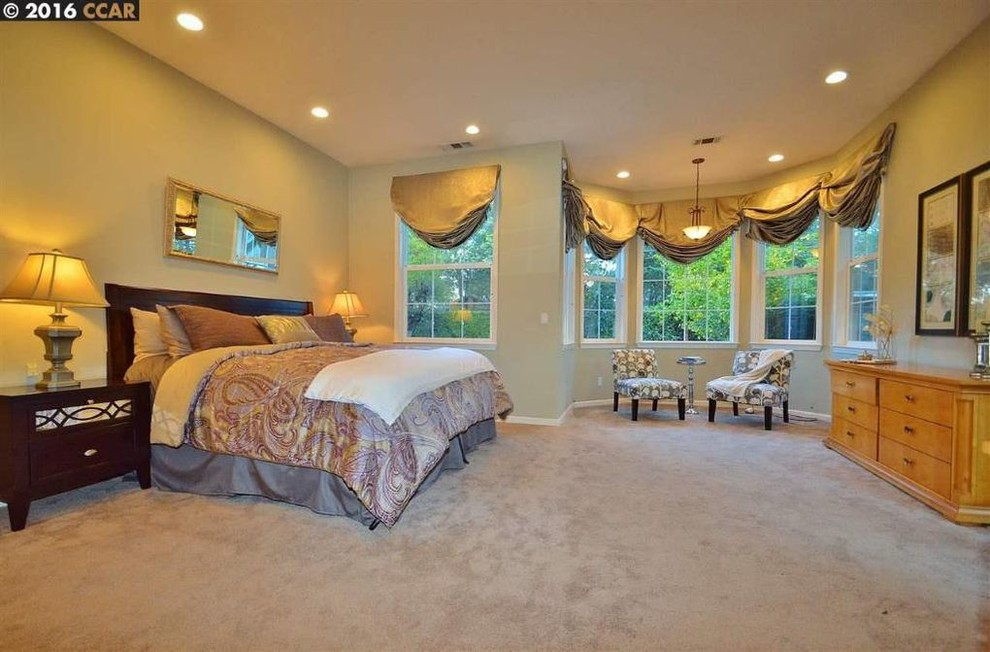 This is an example of a transitional master bedroom in San Francisco with grey walls and carpet.