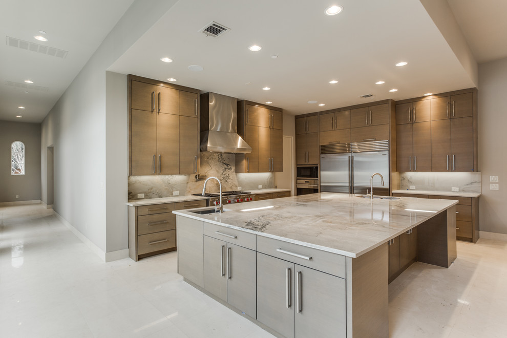 Design ideas for a large transitional l-shaped open plan kitchen in Dallas with a double-bowl sink, flat-panel cabinets, grey cabinets, granite benchtops, grey splashback, stone slab splashback, stainless steel appliances, limestone floors, with island and white floor.