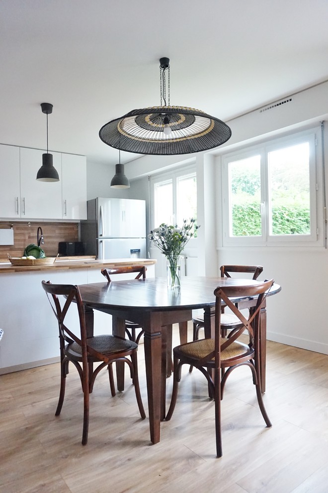 This is an example of a large contemporary open plan kitchen in Paris with white cabinets, laminate benchtops, brown splashback, stainless steel appliances, vinyl floors and with island.