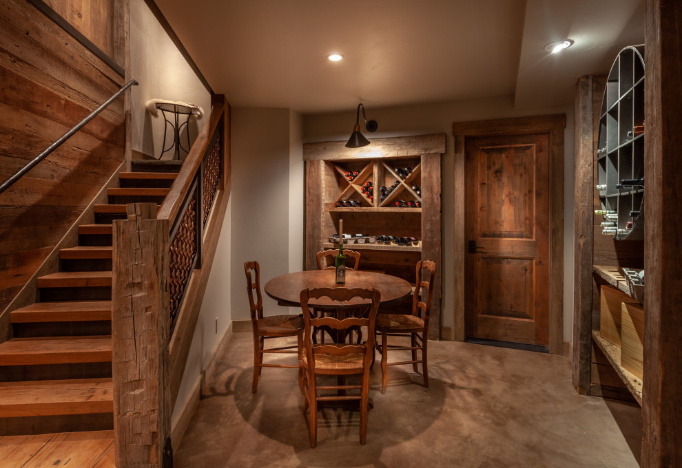 Large country wine cellar in Denver with carpet, diamond bins and brown floor.