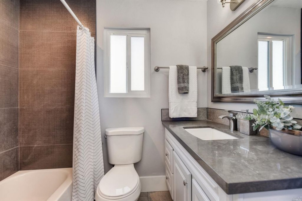 Design ideas for a small modern bathroom in San Francisco with white cabinets, a shower/bathtub combo, an undermount sink, engineered quartz benchtops, a shower curtain and grey benchtops.