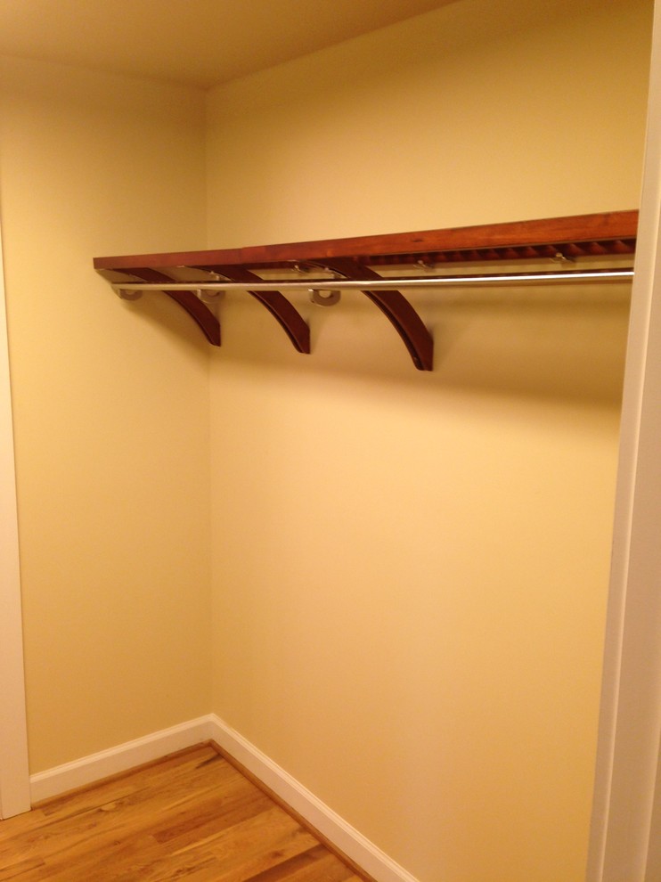 Photo of a small arts and crafts walk-in wardrobe in Charlotte with light hardwood floors.