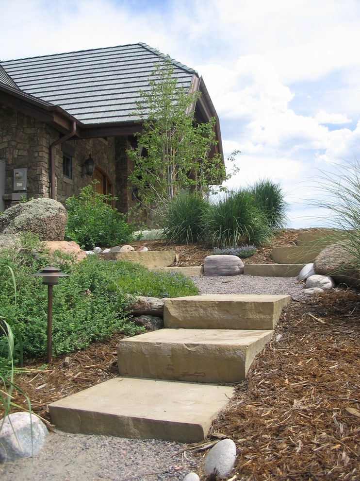 Inspiration for a large country front yard garden in Denver with a water feature and natural stone pavers.