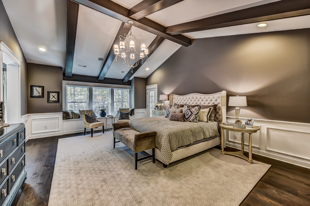 Expansive master bedroom in Charlotte with purple walls, dark hardwood floors, vaulted and decorative wall panelling.