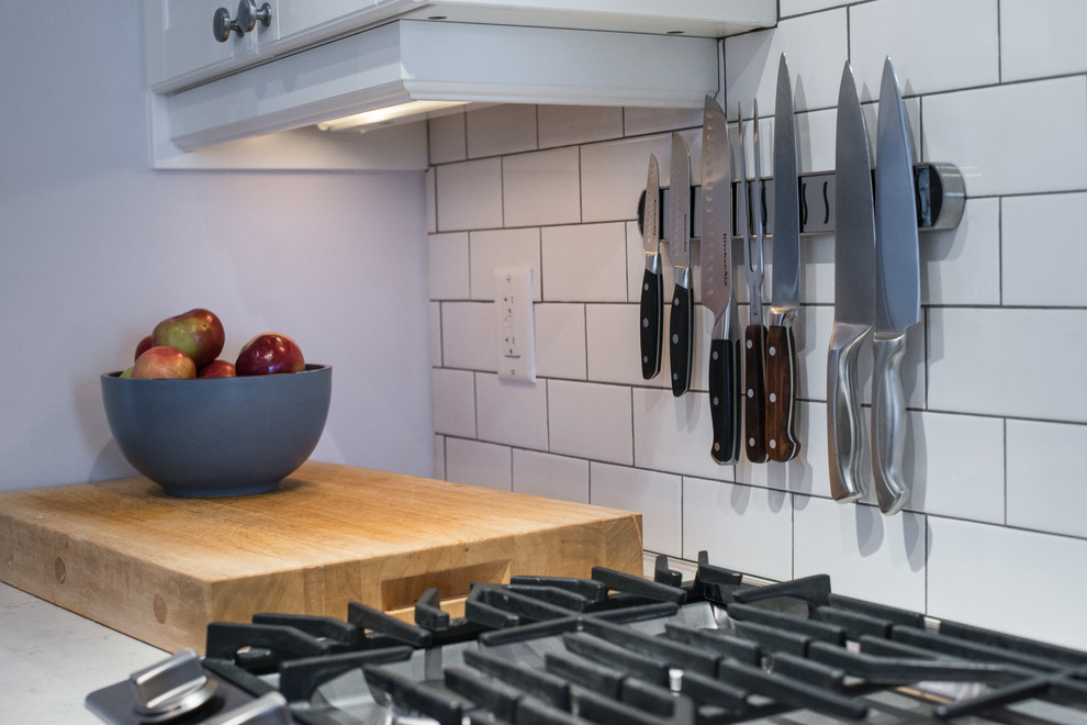 Inspiration for a transitional galley home design remodel in Ottawa with recessed-panel cabinets, black cabinets, quartzite countertops, white backsplash, stainless steel appliances and no island