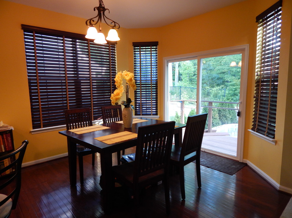 Photo of a medium sized traditional enclosed dining room in DC Metro with yellow walls, dark hardwood flooring and brown floors.