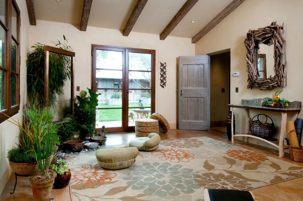 Photo of a large mediterranean home yoga studio in Boise with beige walls, travertine floors and brown floor.