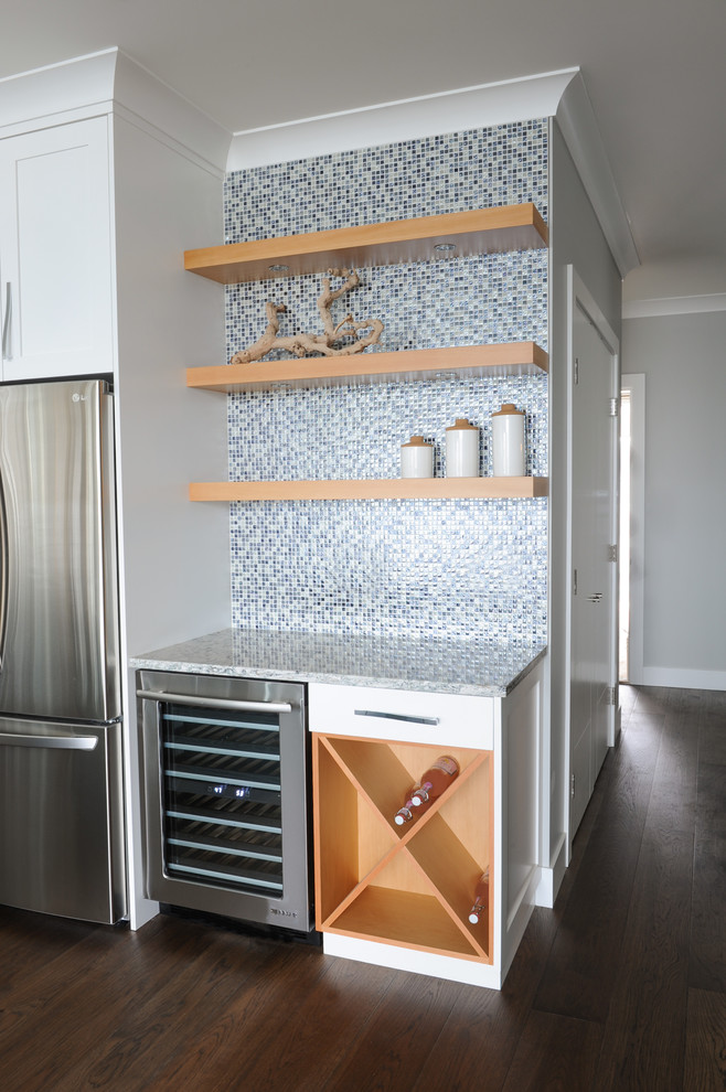 Large transitional u-shaped medium tone wood floor open concept kitchen photo in Vancouver with shaker cabinets, white cabinets, quartz countertops, metallic backsplash, glass tile backsplash and stainless steel appliances