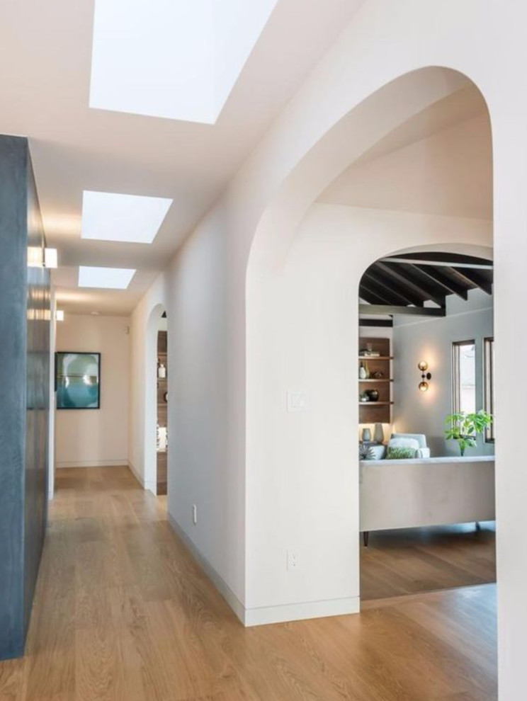 Mid-sized transitional light wood floor hallway photo in Boston with white walls