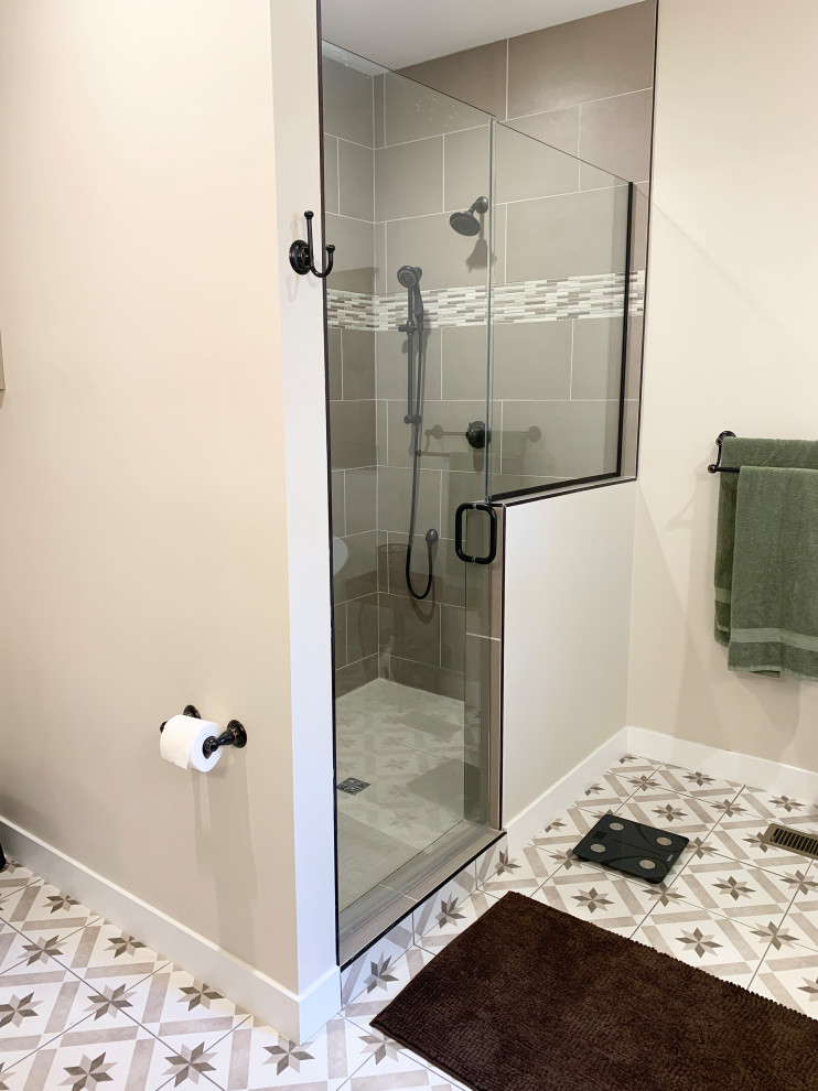 Exempel på ett lantligt badrum, med släta luckor, grå skåp, ett fristående badkar, en dusch i en alkov, grå väggar, klinkergolv i keramik, ett integrerad handfat, flerfärgat golv och dusch med gångjärnsdörr
