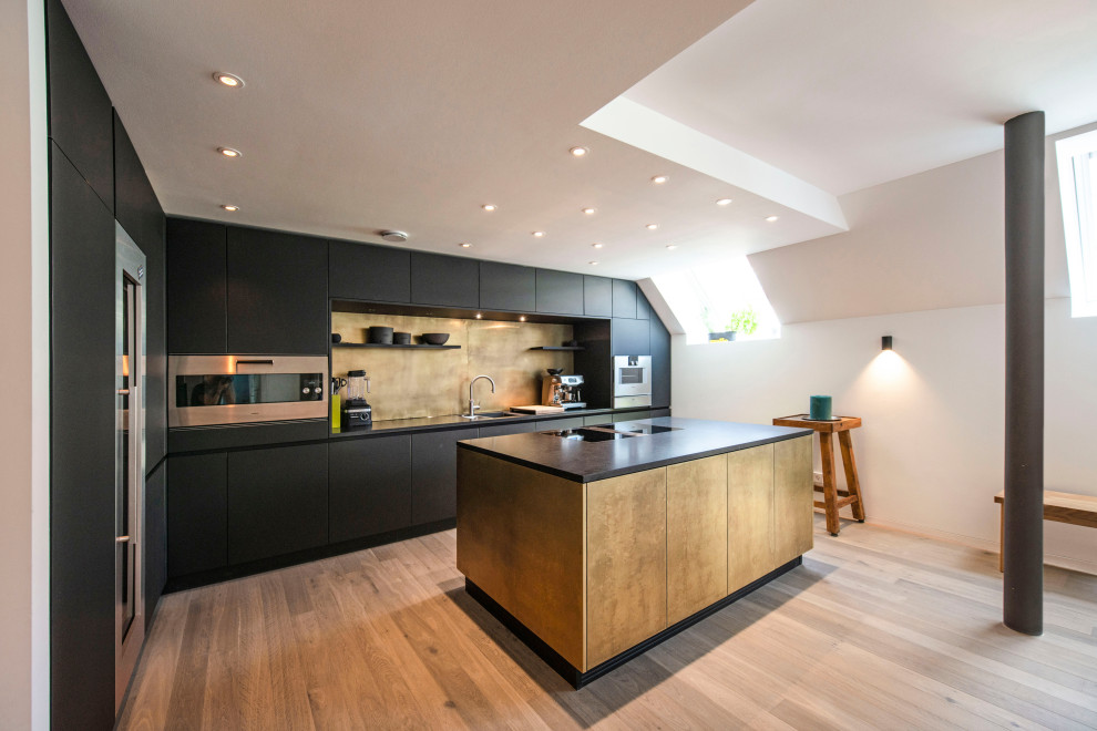 Inspiration for a large contemporary l-shaped open plan kitchen in Munich with a submerged sink, black cabinets, metallic splashback, stainless steel appliances, medium hardwood flooring, an island, brown floors and black worktops.