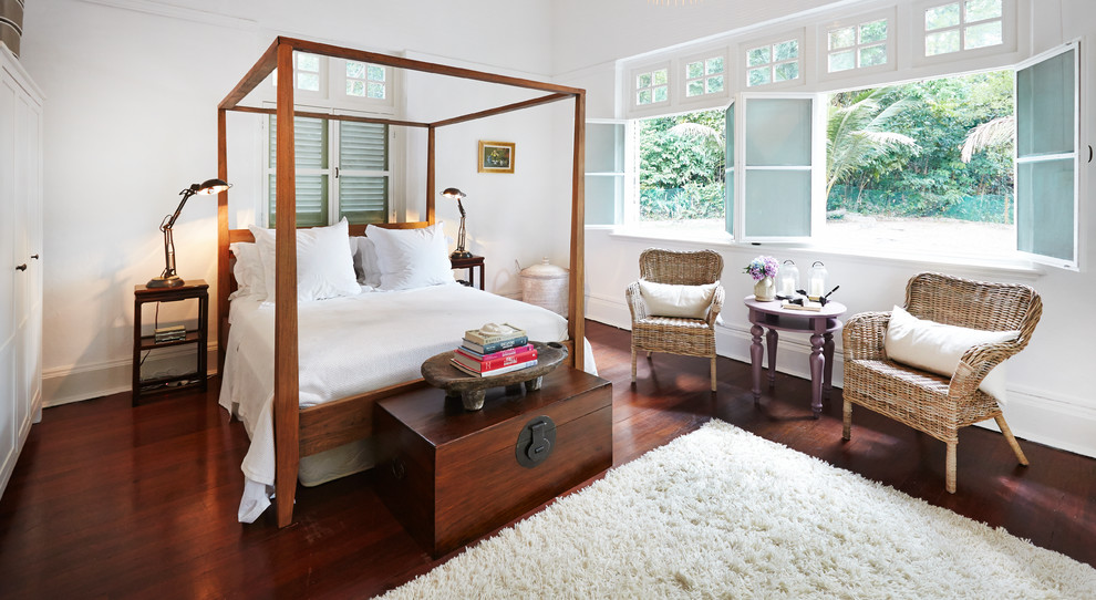 Inspiration for a mid-sized tropical bedroom in London with white walls, medium hardwood floors and red floor.