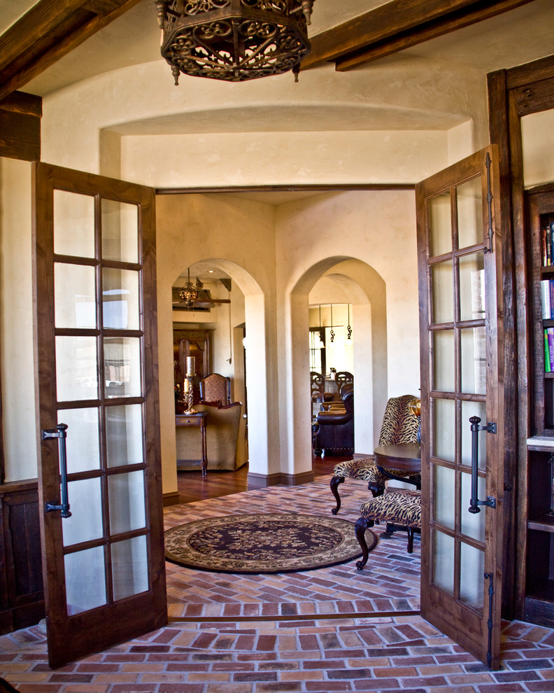 This is an example of a mediterranean foyer in Austin with beige walls and brick floors.