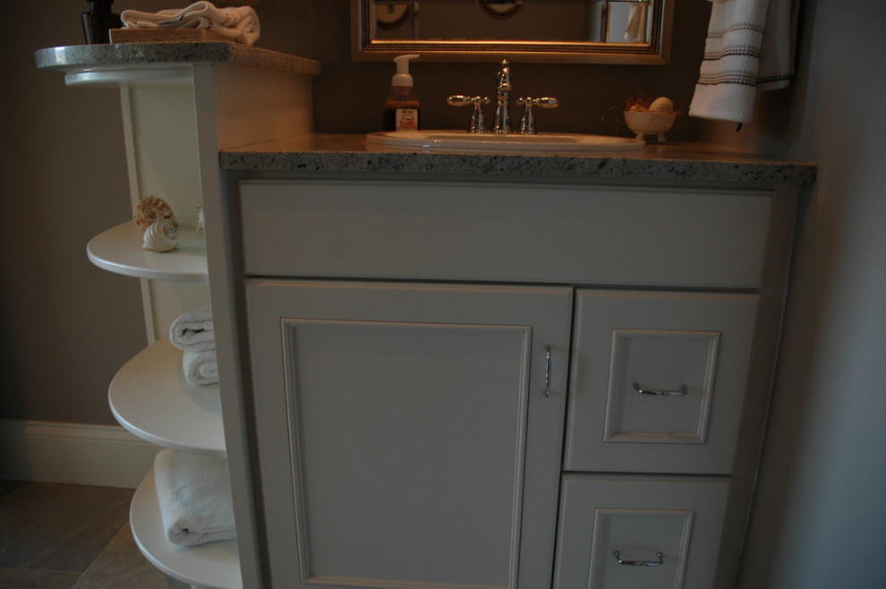 Inspiration for a small transitional 3/4 brown tile and stone tile porcelain tile bathroom remodel with a drop-in sink, flat-panel cabinets, white cabinets, granite countertops, a two-piece toilet and beige walls