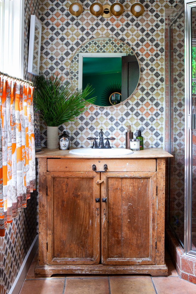 Exempel på ett mellanstort eklektiskt beige beige badrum med dusch, med luckor med infälld panel, en hörndusch, perrakottakakel, flerfärgade väggar, klinkergolv i terrakotta, ett nedsänkt handfat, granitbänkskiva, dusch med gångjärnsdörr, skåp i mellenmörkt trä, flerfärgad kakel, röd kakel och brunt golv
