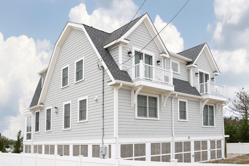 This is an example of a large beach style two-storey grey exterior in Other with vinyl siding and a gable roof.