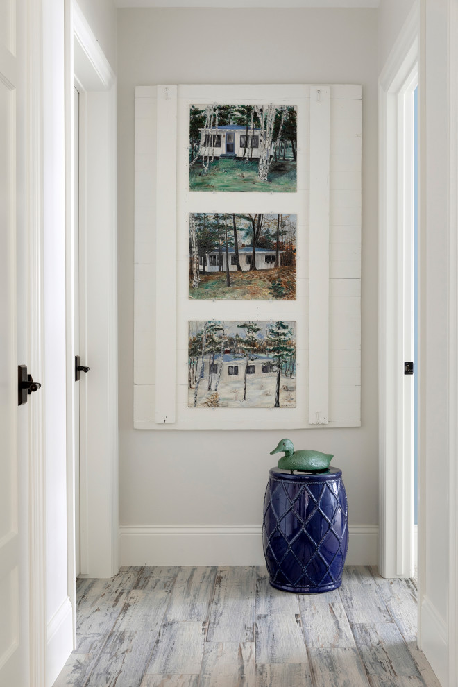Mid-sized beach style hallway in Minneapolis with white walls, porcelain floors and grey floor.