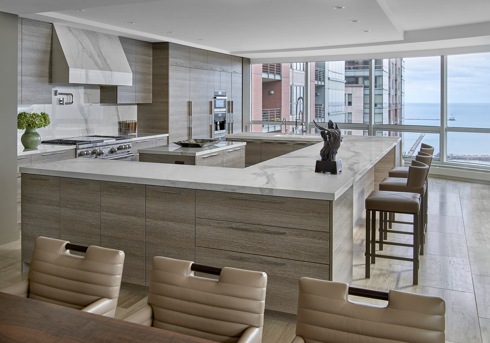 Contemporary eat-in kitchen in Chicago with flat-panel cabinets, white splashback, stainless steel appliances, multiple islands, beige floor, marble benchtops, marble splashback and beige cabinets.