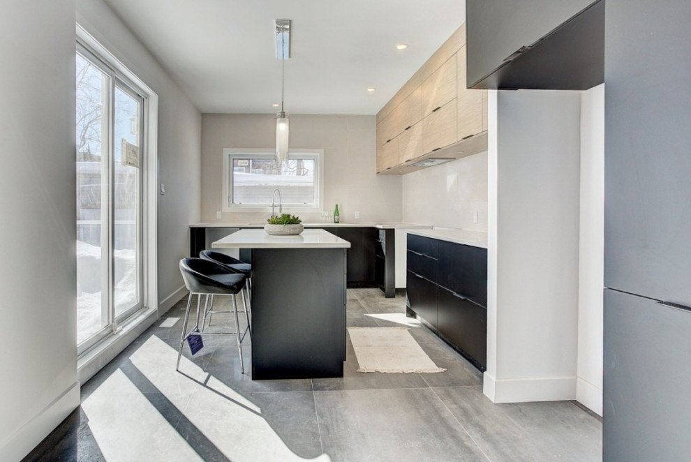 モントリオールにある高級な中くらいなコンテンポラリースタイルのおしゃれなキッチン (フラットパネル扉のキャビネット、黒いキャビネット、クオーツストーンカウンター、ベージュキッチンパネル、セラミックタイルのキッチンパネル、セラミックタイルの床、グレーの床、白いキッチンカウンター) の写真