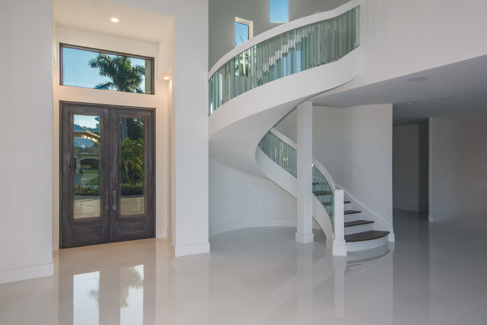 Large modern foyer in Miami with white walls, porcelain floors, a double front door, a dark wood front door and white floor.