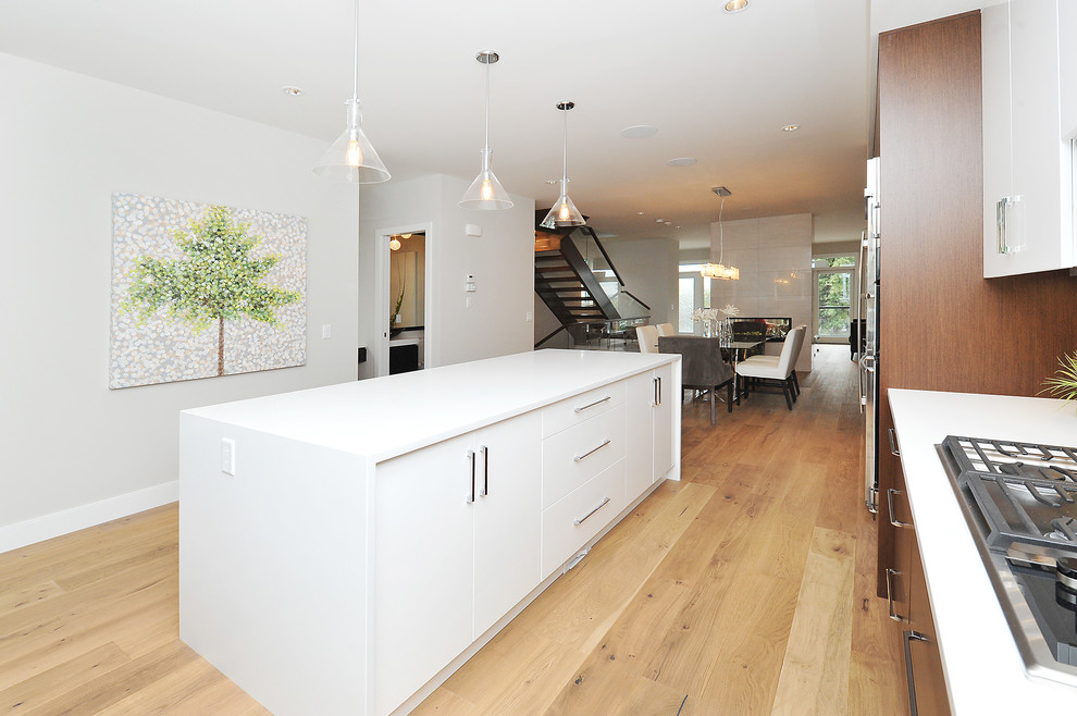 Eat-in kitchen - large transitional l-shaped medium tone wood floor eat-in kitchen idea in Calgary with an undermount sink, flat-panel cabinets, medium tone wood cabinets, gray backsplash, stainless steel appliances and an island