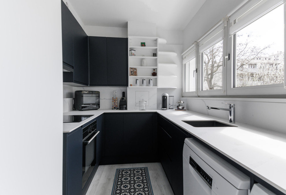 Modern kitchen in Paris with white splashback and white benchtop.
