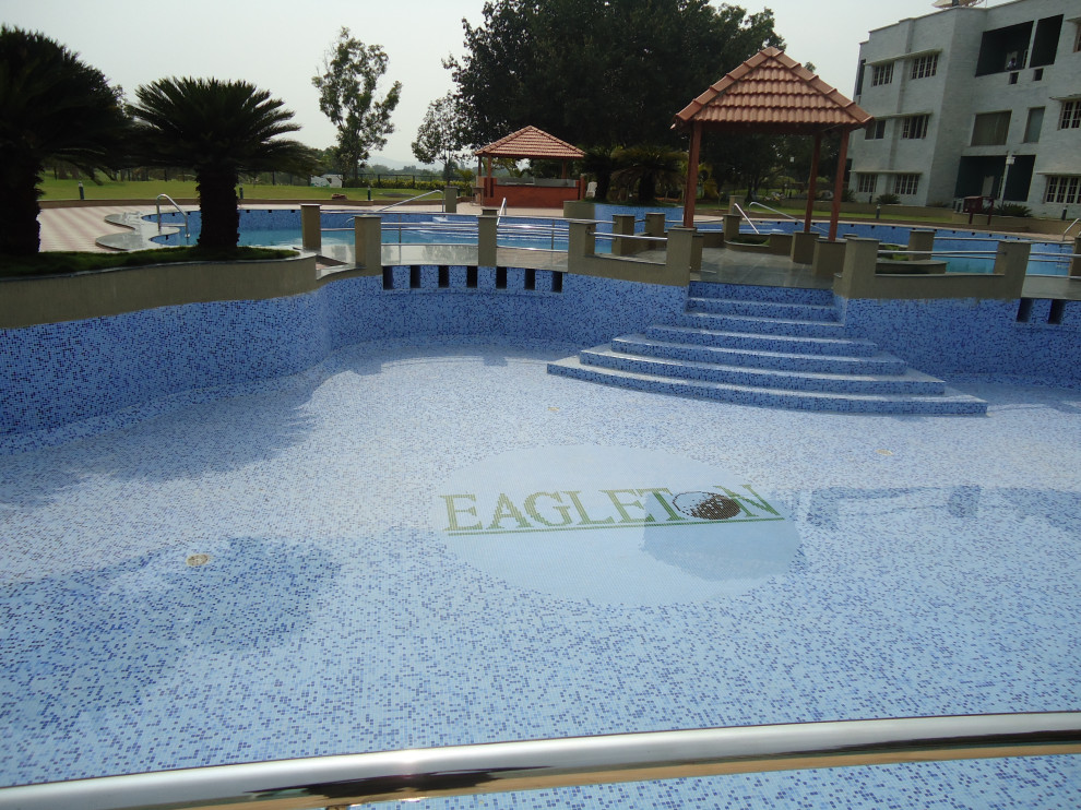 Example of a courtyard tile and custom-shaped pool design