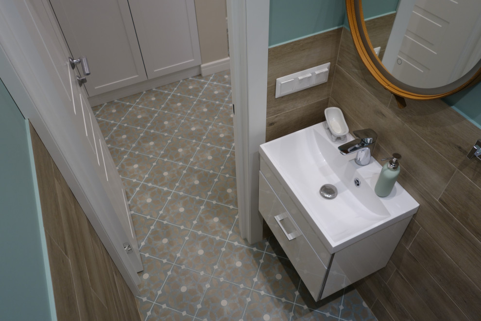 Medium sized nautical cloakroom in Moscow with flat-panel cabinets, white cabinets, a wall mounted toilet, brown tiles, porcelain tiles, blue walls, porcelain flooring, a built-in sink, beige floors, feature lighting, a floating vanity unit and a drop ceiling.