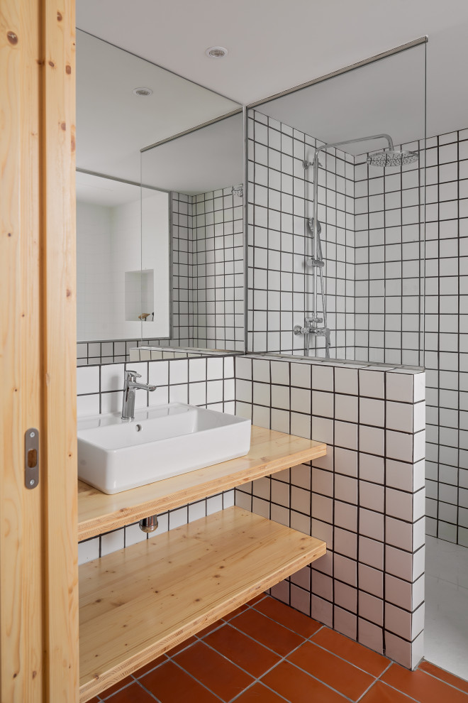 Small mediterranean 3/4 bathroom in Barcelona with white cabinets, a curbless shower, a one-piece toilet, white tile, ceramic tile, white walls, ceramic floors, a vessel sink, wood benchtops, brown floor, an open shower, brown benchtops, a double vanity and a floating vanity.
