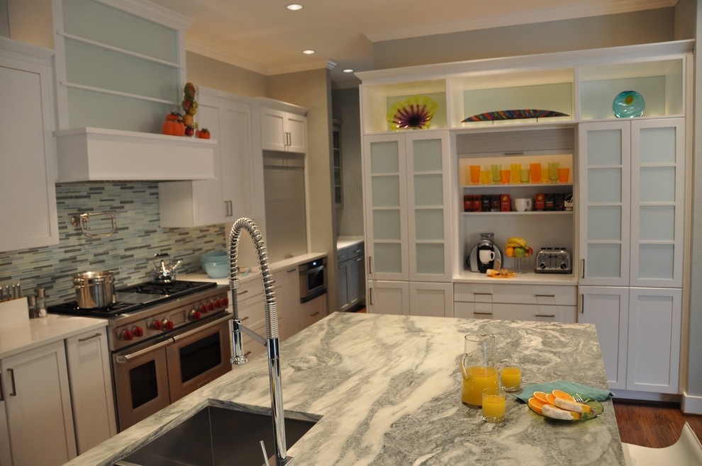 Inspiration for a mid-sized contemporary kitchen in Dallas with recessed-panel cabinets, white cabinets, grey splashback, matchstick tile splashback, stainless steel appliances, medium hardwood floors, with island, an undermount sink and marble benchtops.