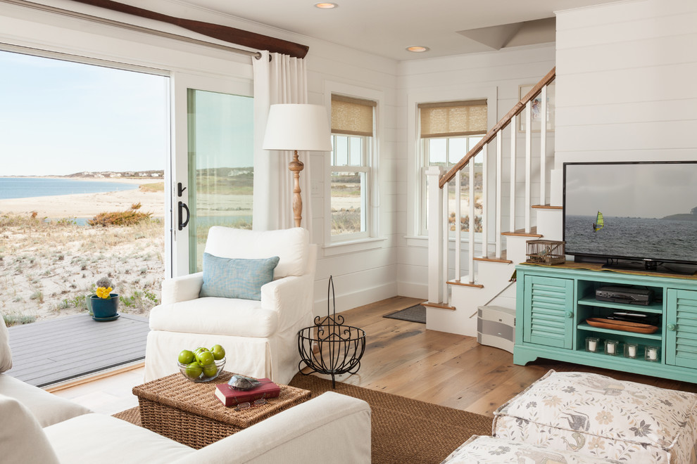 Inspiration for a beach style living room in Boston with white walls, a freestanding tv and light hardwood floors.