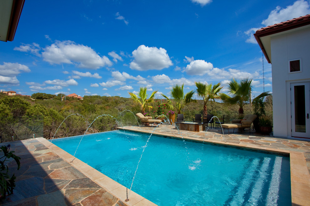 Inspiration for a mid-sized rustic backyard stone and rectangular infinity pool remodel in Austin